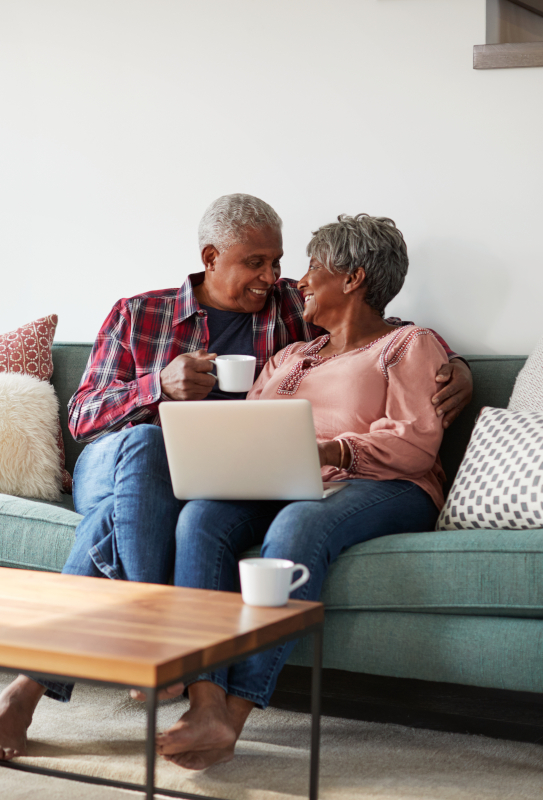 Couple sitting on couch with computer