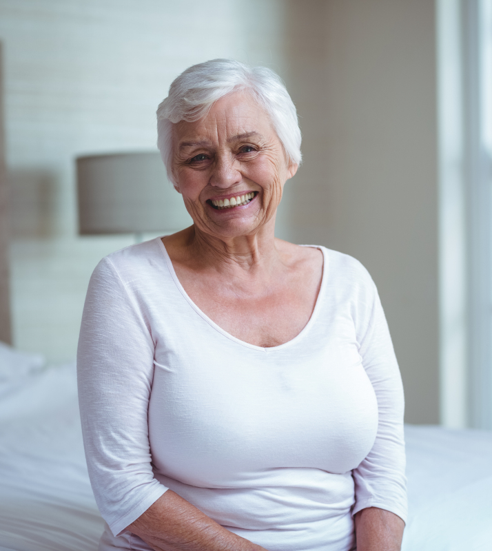 Older woman sitting on bed
