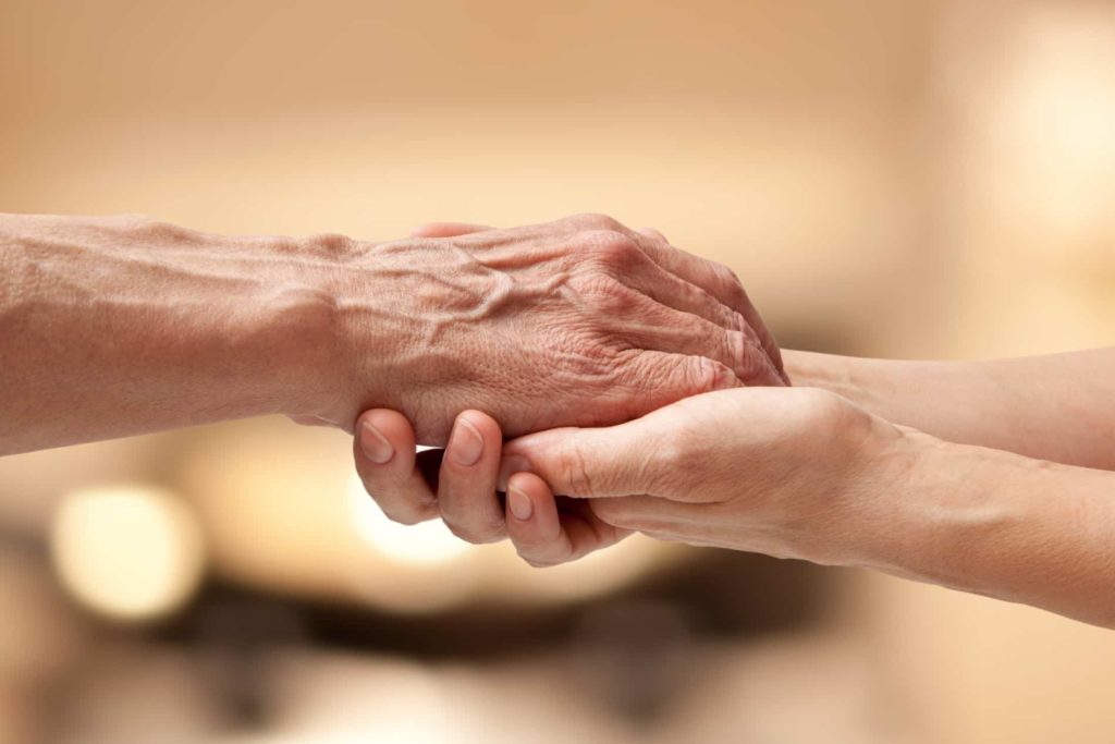 old person's hand holding a young person's hand