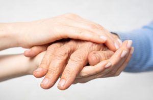 Senior hand held by caretaker