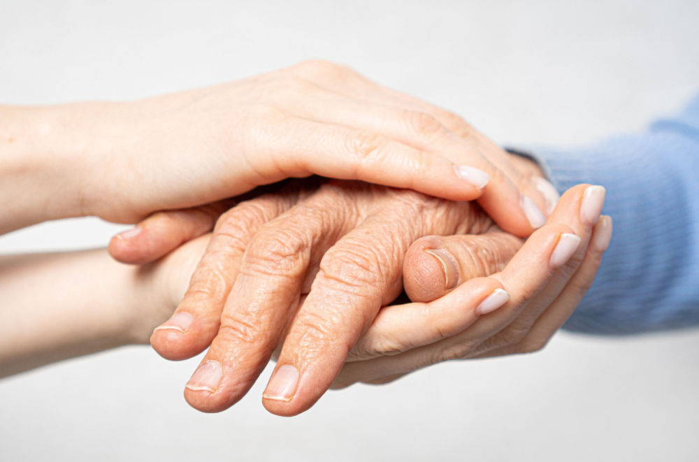 Senior hand held by caretaker