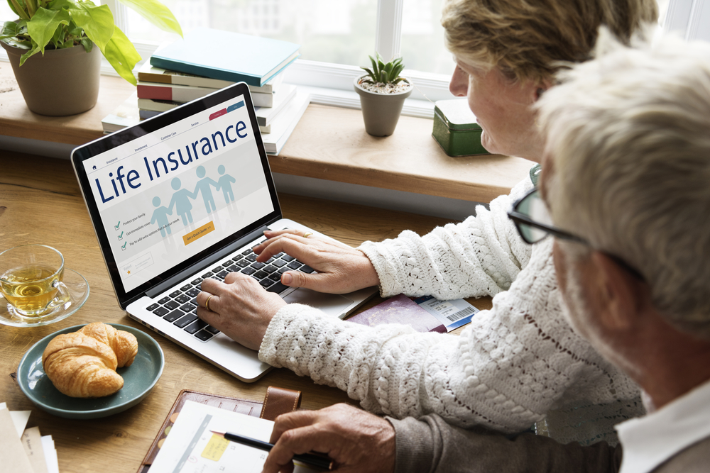 Senior couple looking at a life insurance policy website